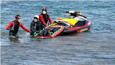  Des secouristes transportent le corps d'un migrant décédé, sur la plage d'Orzola, dans l'île canarienne de Lanzarote, en Espagne, le 18 juin 2021. REUTERS - BORJA SUAREZ 