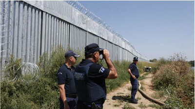 Des policiers grecs patrouillent le long d'une clôture en acier construite le long du fleuve Evros, à la frontière avec la Turquie, le 22 août 2021. Crédit : EPA