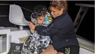 Une touriste italienne enlace un jeune homme syrien qui vient d'être secouru en mer Égée, au large de l'île grecque de Kos, le 25 août 2022. Crédit : ANSA/ MARCO LUIGI DAL MONTE CASONI