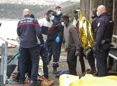 Des pompiers et des policiers français entourent des migrants secourus après des difficultés lors d’une tentative de traversée de la Manche pour rejoindre l’Angleterre, à Calais (Nord), le 1er avril. BERNARD BARRON / AFP