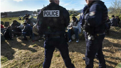 Image d'archives de policiers face à un groupe de migrants recevant des repas fournis par une ONG locale, à Calais, le 1er avril 2017. Crédit : Getty Images