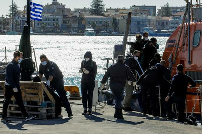 Des migrants débarquent d’un navire des garde-côtes helléniques après avoir été secourus en pleine mer, sur l’île de Chios, en Grèce, le 26 octobre 2021. EUROKINISSI / REUTERS