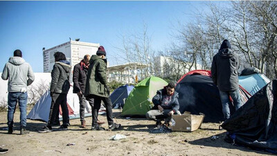 Des migrants dans un campement informel à Calais. Crédit : EPA