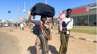 Un couple et leur enfant se dirigent vers la gare routière de Khartoum, au Soudan, dans l'espoir de fuir les combats dans la ville. Crédit : Reuters