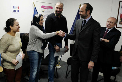 Edouard Philippe, alors premier ministre, et des réfugiés venant de signer leur contrat d’intégration républicaine, à Lyon, en 2018. JEAN-PHILIPPE KSIAZEK / AFP