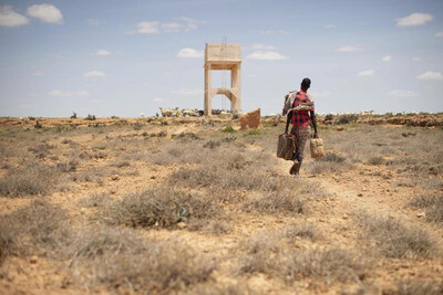 Un éleveur de chameaux se dirige vers un forage pour remplir des jerrycans au Puntland, en Somalie. Les puits et les forages sont à sec alors que le pays connaît sa pire sécheresse depuis des décennies. Photo : OIM/Tobin Jones 2020