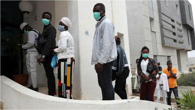 Des immigrés africains font la queue pour recevoir des cartons de secours distribuées par la mairie de Raoued à Tunis, Tunisie, le 22 avril 2020. Crédit : EPA